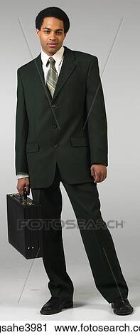 Confident businessman in black suit with briefcase View Large Photo Image Stock Image - Confident businessman in black suit with briefcase. Fotosearch
