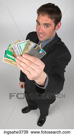 Executive holding up credit cards View Large Photo Image Stock Photo - Executive holding up credit cards . Fotosearch