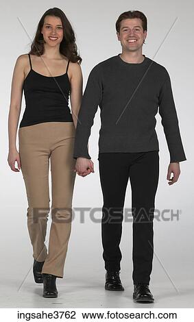 Happy couple walking hand in hand View Large Photo Image Stock Image - Happy couple walking hand in hand . Fotosearch