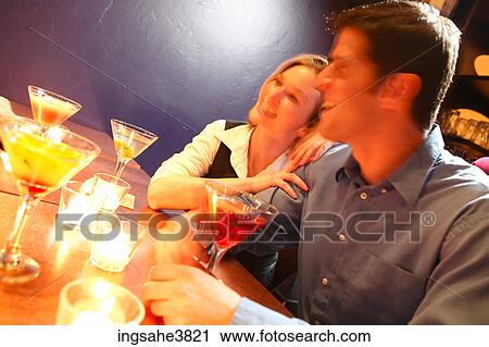Laughing couple sitting at the bar in front of cocktails View Large Photo Image Stock Image - Laughing couple sitting at the bar in front of cocktails. Fotosearch