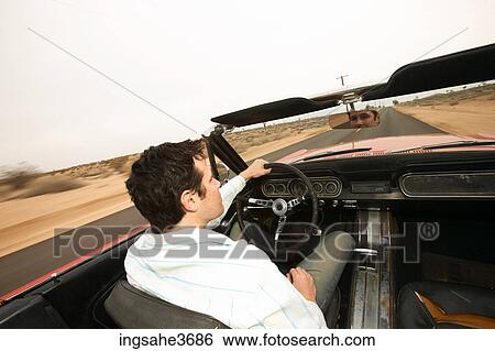 Stock Photograph - Male young adult driving car . Fotosearch
