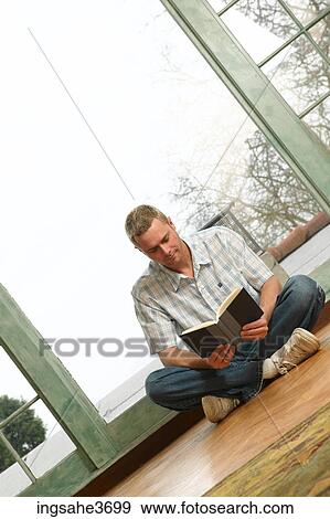 Stock Photo - Male young adult sitting in chair . Fotosearch