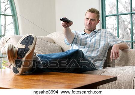 Picture - Male young adult sitting on couch . Fotosearch