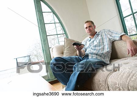 Male young adult sitting on couch View Large Photo Image Stock Image - Male young adult sitting on couch . Fotosearch