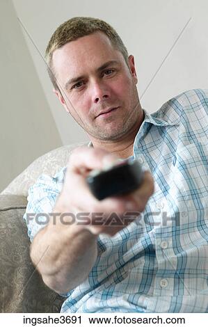 Male young adult sitting on couch View Large Photo Image Stock Image - Male young adult sitting on couch . Fotosearch