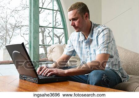 Stock Photograph - Male young adult sitting on couch . Fotosearch