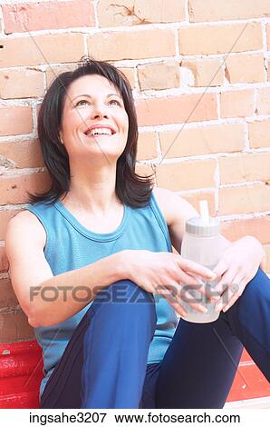 Mature adult woman smiling with water bottle View Large Photo Image Stock Photo - Mature adult woman smiling with water bottle . Fotosearch
