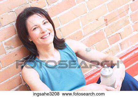 Mature adult woman smiling with water bottle View Large Photo Image Stock Photo - Mature adult woman smiling with water bottle . Fotosearch