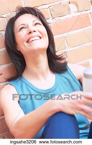 Stock Photograph - Mature adult woman smiling with water bottle . Fotosearch