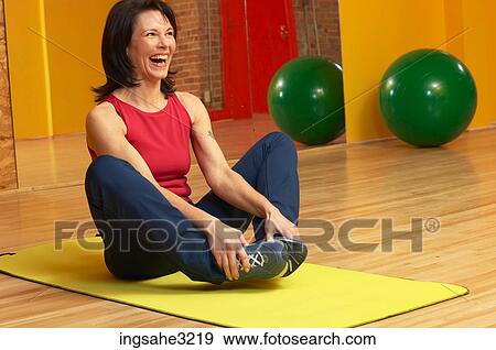 Mature adult woman stretching on exercise mat View Large Photo Image Stock Photo - Mature adult woman stretching on exercise mat . Fotosearch