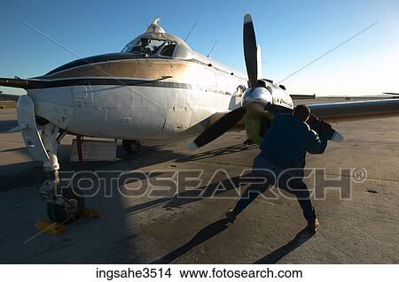 Mechanic pulling on propeller View Large Photo Image Picture - Mechanic pulling on propeller . Fotosearch