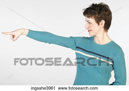 Stock Image - Pointing woman in blue sweater. Fotosearch