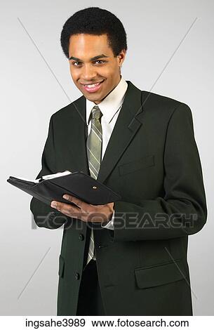 Smiling businessman writing in day planner View Large Photo Image Stock Photo - Smiling businessman writing in day planner. Fotosearch