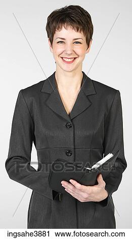 Smiling businesswoman holding open day planner View Large Photo Image Stock Image - Smiling businesswoman holding open day planner. Fotosearch