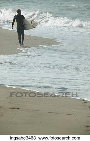 Surfer walking beach View Large Photo Image Stock Image - Surfer walking beach . Fotosearch