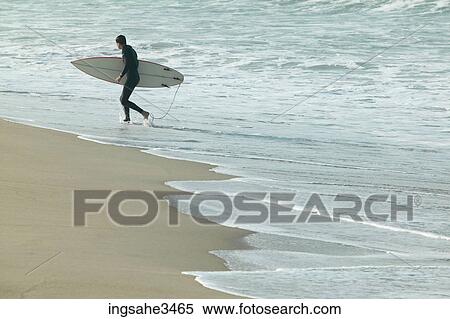 Surfer walking beach View Large Photo Image Stock Photography - Surfer walking beach . Fotosearch