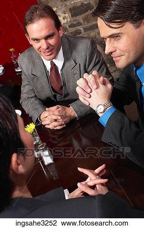 Stock Image - Three business people at meeting . Fotosearch