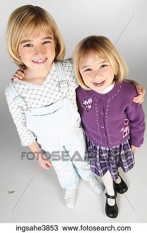 Two blonde girls holding each other and smiling View Large Photo Image Stock Image - Two blonde girls holding each other and smiling. Fotosearch
