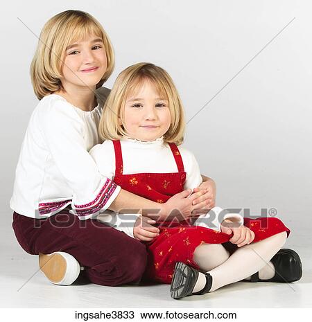 Two blonde girls sitting cross legged on the floor View Large Photo Image Stock Image - Two blonde girls sitting cross legged on the floor. Fotosearch