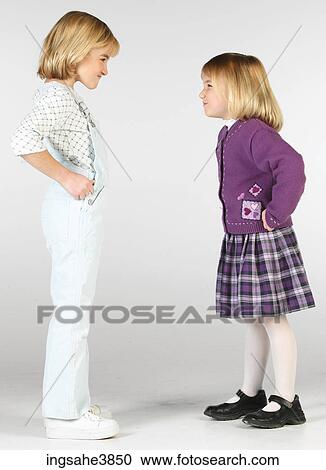 Two Caucasian blonde girls standing and frowning at each other View Large Photo Image Stock Image - Two Caucasian blonde girls standing and frowning at each other. Fotosearch