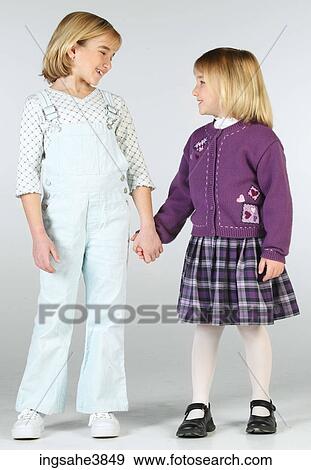 Two Caucasian blonde girls standing and smiling at each other View Large Photo Image Stock Photo - Two Caucasian blonde girls standing and smiling at each other. Fotosearch