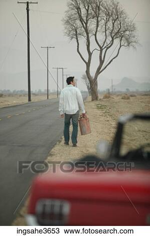 Stock Image - Walking down road with gas can . Fotosearch