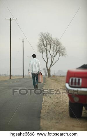 Stock Photo - Walking down road with gas can . Fotosearch