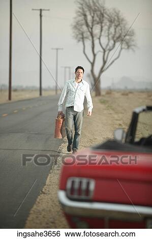 Stock Photograph - Walking down road with gas can . Fotosearch
