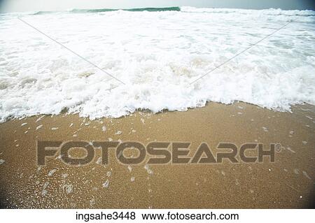 Wave and foam on beach  View Large Photo Image Stock Photo - Wave and foam on beach . Fotosearch