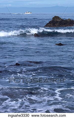 waves on rocky coast with motor boat in background View Large Photo Image Stock Image - waves on rocky coast with motor boat in background . Fotosearch