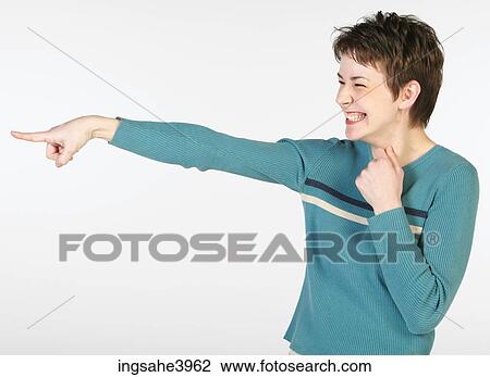 Woman pointing and giggling in blue sweater View Large Photo Image Stock Image - Woman pointing and giggling in blue sweater. Fotosearch