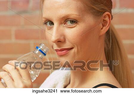 Young female adult drinking from water bottle View Large Photo Image Stock Image - Young female adult drinking from water bottle . Fotosearch