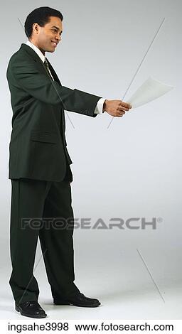Young man smiling and holding out a memo View Large Photo Image Stock Photo - Young man smiling and holding out a memo . Fotosearch