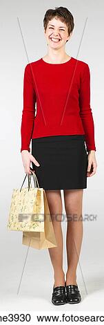 Young woman carrying shopping bags and grinning View Large Photo Image Stock Image - Young woman carrying shopping bags and grinning. Fotosearch