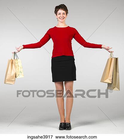 Young woman carrying shopping bags View Large Photo Image Stock Photo - Young woman carrying shopping bags. Fotosearch