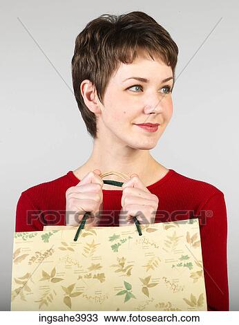 Young woman clutching shopping bags and smiling View Large Photo Image Stock Image - Young woman clutching shopping bags and smiling . Fotosearch