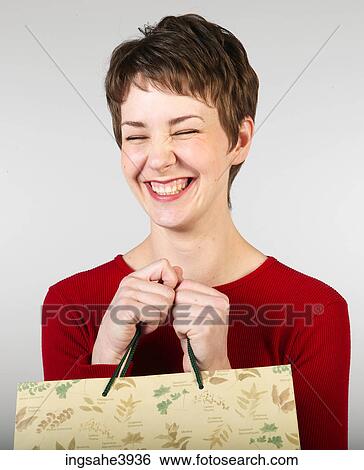 Young woman clutching shopping bags and grinning View Large Photo Image Stock Photograph - Young woman clutching shopping bags and grinning. Fotosearch