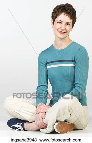 Young woman sitting cross legged on the floor and smiling View Large Photo Image Stock Photo - Young woman sitting cross legged on the floor and smiling . Fotosearch