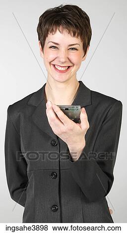 Stock Photo - Young woman smiling and holding a personal digital assistant. Fotosearch