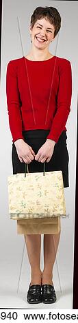 Young woman smiling and holding shopping bags View Large Photo Image Stock Image - Young woman smiling and holding shopping bags . Fotosearch