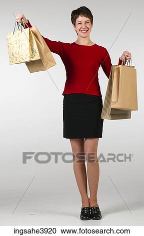Young woman smiling and posing with shopping bags View Large Photo Image Stock Image - Young woman smiling and posing with shopping bags . Fotosearch