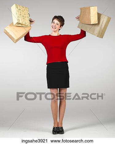 Young woman smiling and posing with shopping bags View Large Photo Image Stock Image - Young woman smiling and posing with shopping bags. Fotosearch