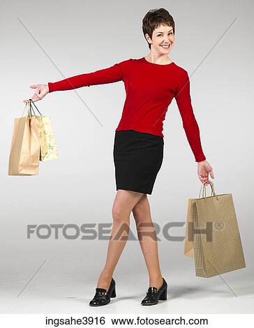 Young woman smiling and posing with shopping bags View Large Photo Image Stock Photograph - Young woman smiling and posing with shopping bags . Fotosearch
