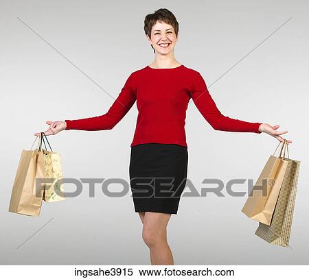 Young woman smiling and posing with shopping bags View Large Photo Image Stock Photography - Young woman smiling and posing with shopping bags . Fotosearch