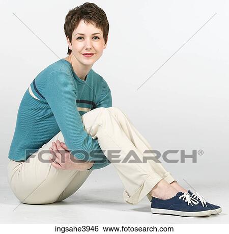Young woman smiling and sitting on the floor View Large Photo Image Stock Photograph - Young woman smiling and sitting on the floor . Fotosearch