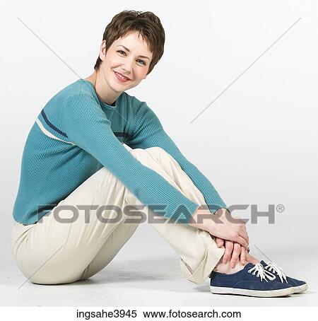 Young woman smiling and sitting on the floor View Large Photo Image Stock Photography - Young woman smiling and sitting on the floor. Fotosearch