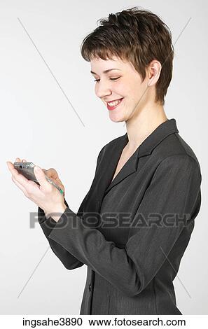 Young woman smiling while using a palm held computing device View Large Photo Image Stock Image - Young woman smiling while using a palm held computing device . Fotosearch