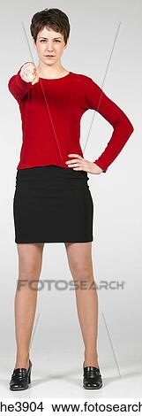 Picture - Young woman standing and pointing. Fotosearch
