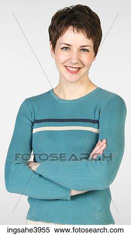 Young woman standing with her arms folded and smiling View Large Photo Image Stock Photography - Young woman standing with her arms folded and smiling . Fotosearch