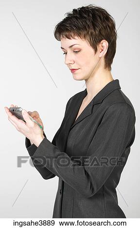 Young woman using a palm held electronic device View Large Photo Image Stock Photo - Young woman using a palm held electronic device. Fotosearch